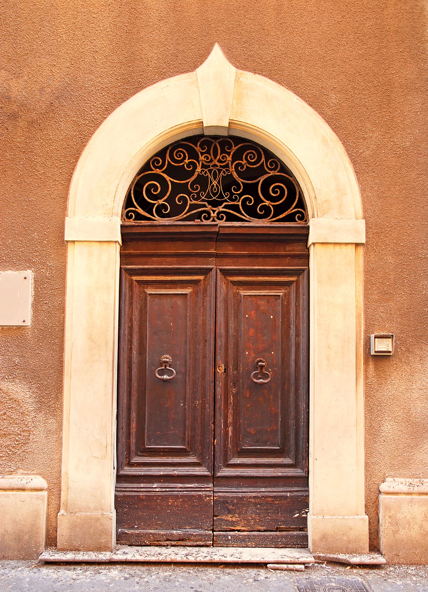 An arched wooden door in a stone facade